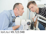 Optician showing machinery to apprentice. Стоковое фото, агентство Ingram Publishing / Фотобанк Лори