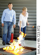 woman showing how to operate fire extinguisher. Стоковое фото, агентство Ingram Publishing / Фотобанк Лори