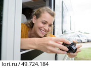 woman taking photograph from campervan window. Стоковое фото, агентство Ingram Publishing / Фотобанк Лори