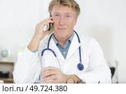 doctor sitting in hospital with many conflicting prioritie. Стоковое фото, агентство Ingram Publishing / Фотобанк Лори