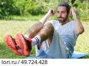 man doing abdominal crunches outdoor. Стоковое фото, агентство Ingram Publishing / Фотобанк Лори