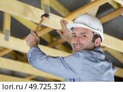 male construction worker builder crouching lywood board. Стоковое фото, агентство Ingram Publishing / Фотобанк Лори