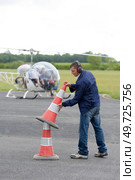 man putting out safety cones at an airfield. Стоковое фото, агентство Ingram Publishing / Фотобанк Лори