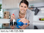 young happy woman is cleaning the kitchen. Стоковое фото, агентство Ingram Publishing / Фотобанк Лори