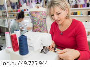 middle aged woman using a sewing machine. Стоковое фото, агентство Ingram Publishing / Фотобанк Лори
