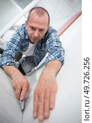 a craftsman fitting a carpet. Стоковое фото, агентство Ingram Publishing / Фотобанк Лори