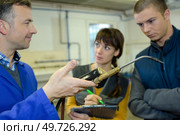 ironworks teacher showing students how to securely use gas welder. Стоковое фото, агентство Ingram Publishing / Фотобанк Лори
