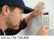 a male technician repairing intercom. Стоковое фото, агентство Ingram Publishing / Фотобанк Лори
