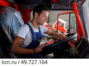 fireman behind steering wheel of a firefighting truck. Стоковое фото, агентство Ingram Publishing / Фотобанк Лори