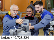 portrait of senior factory manager with apprentices. Стоковое фото, агентство Ingram Publishing / Фотобанк Лори