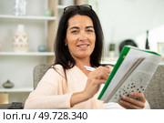 a beautiful woman doing crosswords in room. Стоковое фото, агентство Ingram Publishing / Фотобанк Лори