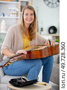 woman repairing a guitar string. Стоковое фото, агентство Ingram Publishing / Фотобанк Лори