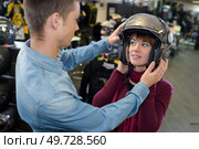 woman trying on a motorcycle helmet. Стоковое фото, агентство Ingram Publishing / Фотобанк Лори