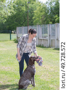 dedicated girl training dog in kennel. Стоковое фото, агентство Ingram Publishing / Фотобанк Лори
