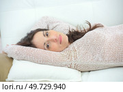 Lady layed on couch, arms behind head. Стоковое фото, агентство Ingram Publishing / Фотобанк Лори