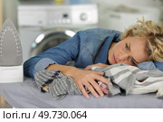 disappointed unhappy housewife leaning on a pile of laundry. Стоковое фото, агентство Ingram Publishing / Фотобанк Лори