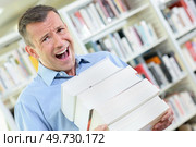an upset man with books. Стоковое фото, агентство Ingram Publishing / Фотобанк Лори
