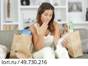 woman checking a long receipt after doing grocery shopping. Стоковое фото, агентство Ingram Publishing / Фотобанк Лори