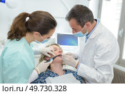 dentist and nurse are curing a female patient. Стоковое фото, агентство Ingram Publishing / Фотобанк Лори