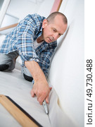 man cutting the edge of linoleum. Стоковое фото, агентство Ingram Publishing / Фотобанк Лори