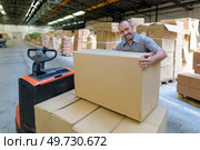 porter carrying boxes in a warehouse. Стоковое фото, агентство Ingram Publishing / Фотобанк Лори