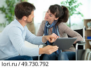 man and disabled woman smiling at eachother using tablet. Стоковое фото, агентство Ingram Publishing / Фотобанк Лори