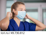 female nurse puts on a facemask. Стоковое фото, агентство Ingram Publishing / Фотобанк Лори