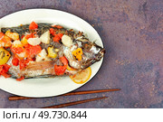 Grilled tilapia fish with fruit in white plate. Flat lay with copy space.. Roasted whole tilapia with citrus sauce. Стоковое фото, агентство Ingram Publishing / Фотобанк Лори