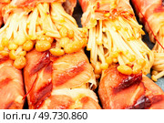 Enoki or enokitake mushroom roasted in bacon on plate. Bacon wrapped mushroom.. Enoki mushroom appetizer fried in bacon. Стоковое фото, агентство Ingram Publishing / Фотобанк Лори