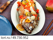 Fried tilapia fish with fruit in white plate. Vietnamese food.. Roasted whole tilapia, Mexican food. Стоковое фото, агентство Ingram Publishing / Фотобанк Лори