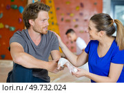 woman bandaging injured hand of a sportman. Стоковое фото, агентство Ingram Publishing / Фотобанк Лори