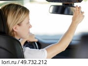 woman adjusting rear view mirror. Стоковое фото, агентство Ingram Publishing / Фотобанк Лори