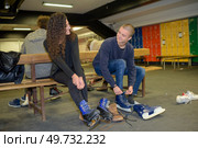 couple putting ice skates on. Стоковое фото, агентство Ingram Publishing / Фотобанк Лори