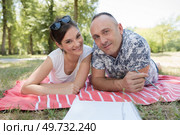 mid-adult couple layed on a blanket in the park. Стоковое фото, агентство Ingram Publishing / Фотобанк Лори
