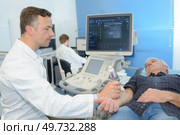 young male doctor using ultrasound scan on senior male patient. Стоковое фото, агентство Ingram Publishing / Фотобанк Лори