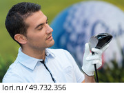 smiling golfer holding golf club. Стоковое фото, агентство Ingram Publishing / Фотобанк Лори
