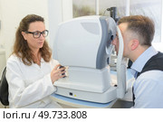 optometrist does an eye exam on patient. Стоковое фото, агентство Ingram Publishing / Фотобанк Лори