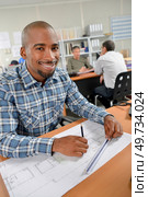 Smiling man working on plans. Стоковое фото, агентство Ingram Publishing / Фотобанк Лори