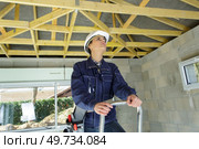 female worker inspecting wooden timbers in renovation property. Стоковое фото, агентство Ingram Publishing / Фотобанк Лори