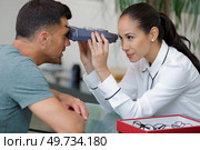 an optician examining patients eyes. Стоковое фото, агентство Ingram Publishing / Фотобанк Лори