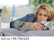 bored woman holding iron about to do ironing. Стоковое фото, агентство Ingram Publishing / Фотобанк Лори