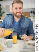 man drinking orange juice at breakfast. Стоковое фото, агентство Ingram Publishing / Фотобанк Лори