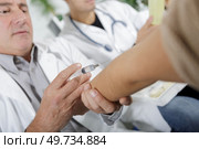 doctor making an injection on patients arm. Стоковое фото, агентство Ingram Publishing / Фотобанк Лори