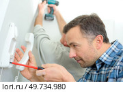 Man repairing an intercom phone. Стоковое фото, агентство Ingram Publishing / Фотобанк Лори