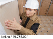 female plasterer installing a material on the wall. Стоковое фото, агентство Ingram Publishing / Фотобанк Лори