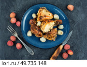 Pieces of baked mustard glazed chicken with lychee on a plate. Top view.. Roasted chicken pieces with lychee. Стоковое фото, агентство Ingram Publishing / Фотобанк Лори