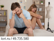 couple ignoring each other sat on their bed. Стоковое фото, агентство Ingram Publishing / Фотобанк Лори