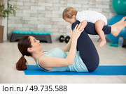 young mother does physical fitness exercises with her baby. Стоковое фото, агентство Ingram Publishing / Фотобанк Лори