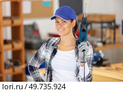 smiling woman in workshop holds a power tool. Стоковое фото, агентство Ingram Publishing / Фотобанк Лори