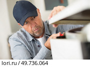 male technician checking electric device. Стоковое фото, агентство Ingram Publishing / Фотобанк Лори
